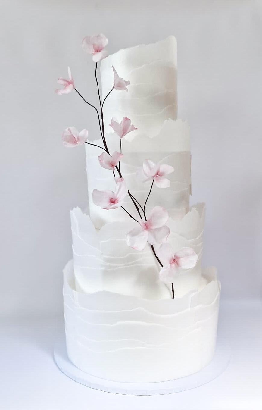 Luxury wedding cake with cascading pink cherry blossom sugar flowers West London