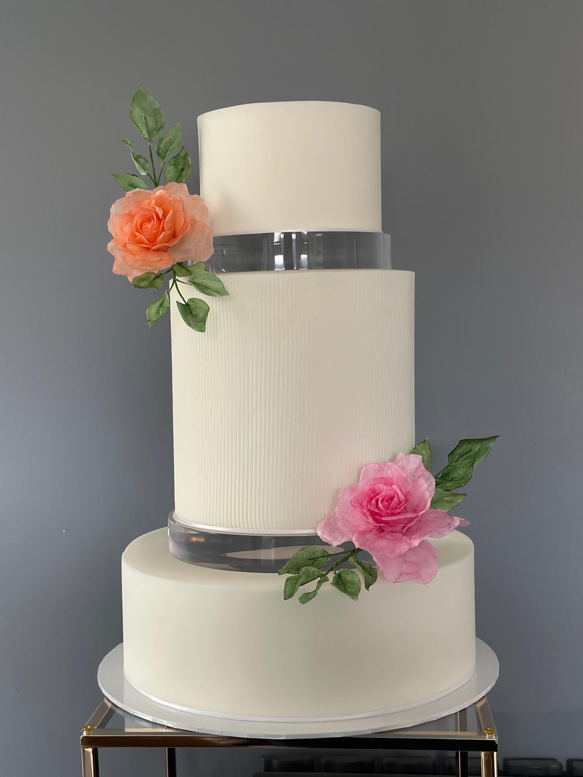 Modern white wedding cake with coral and pink sugar roses, West London wedding cake designer